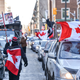 A protester of the vaccine mandates introduced by Canadian Prime Minister Justin Trudeau, walks down Metcalfe Street draped in a Canadian flag on February 5, 2022 in Ottawa, Canada.